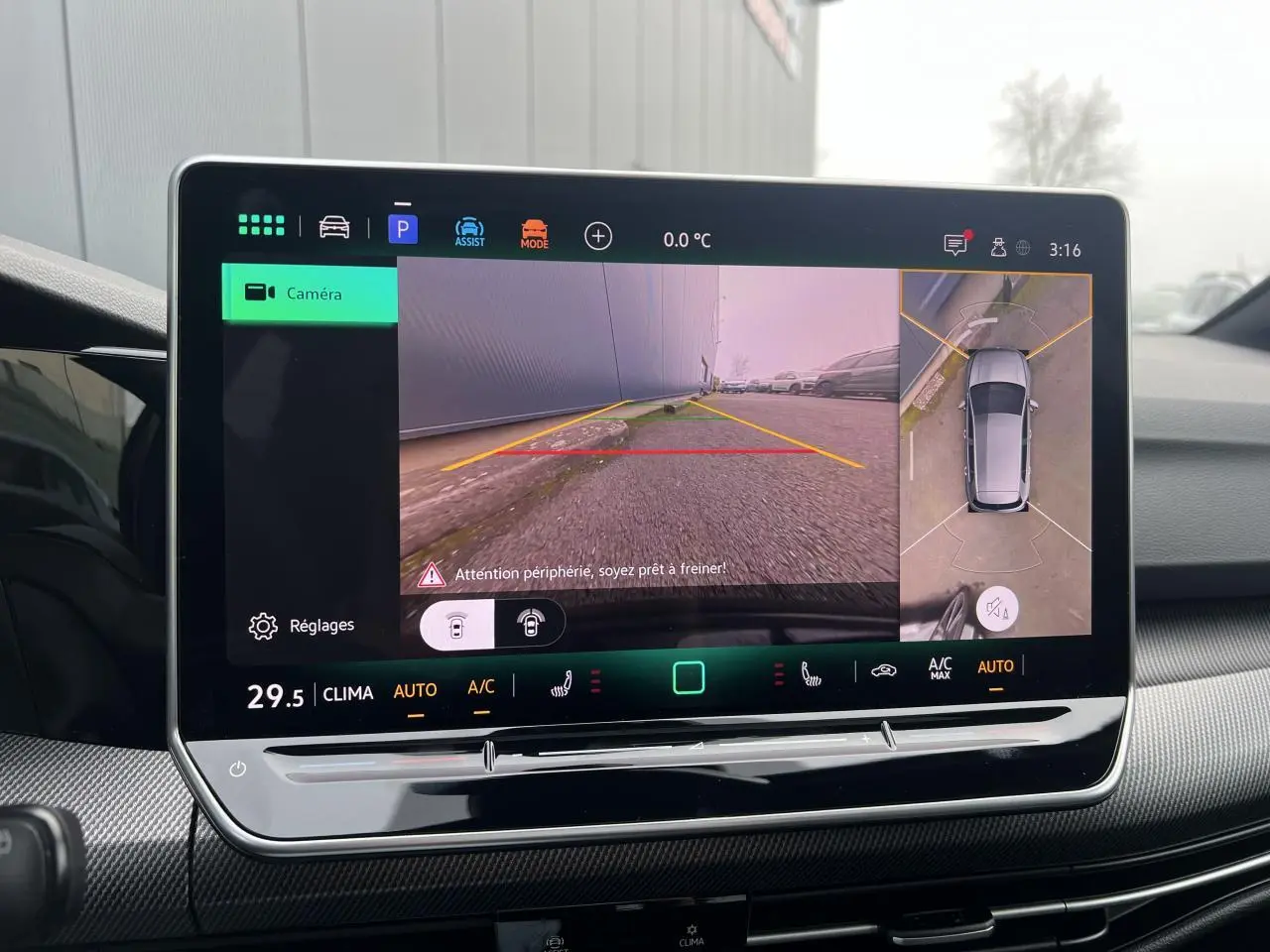 Écran tactile intérieur affichant la caméra 360° et vue arrière de la Volkswagen Golf VIII noire, tableau de bord moderne.