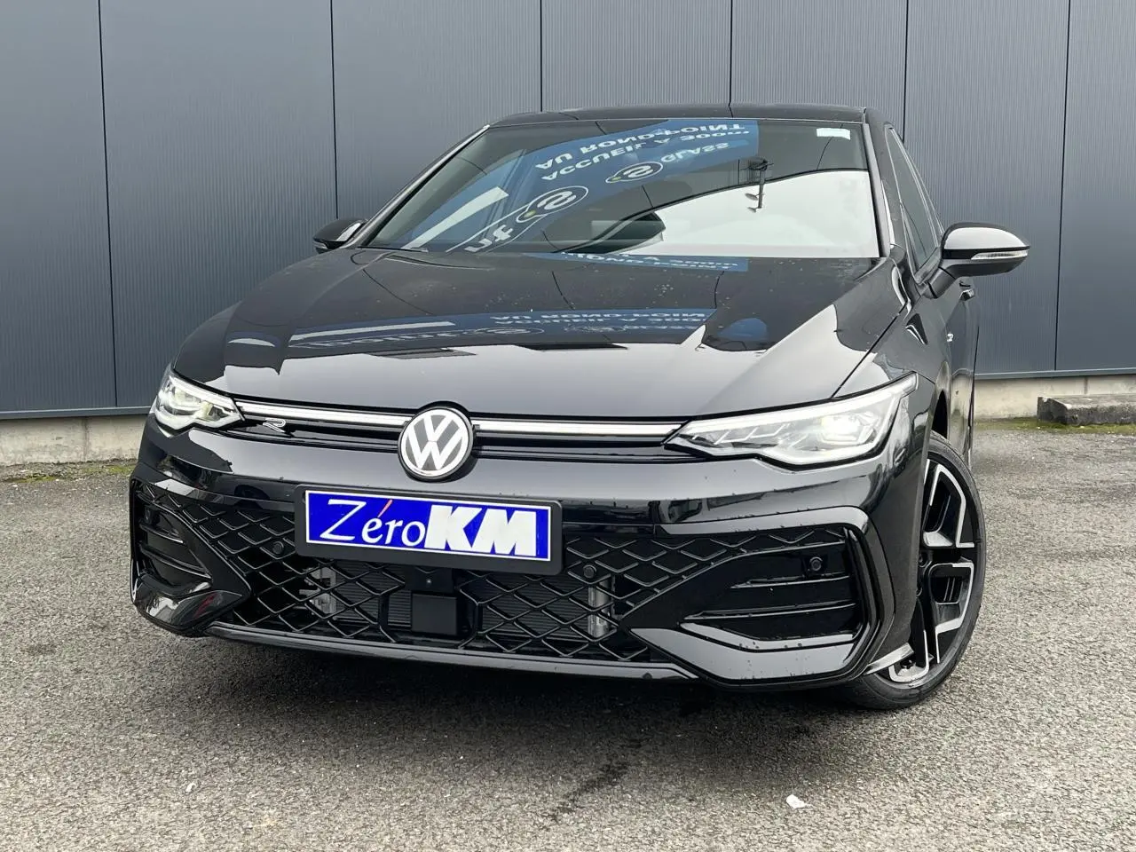 Vue avant d’une Volkswagen Golf VIII noire R-Line avec calandre laquée et jantes alliage 18 pouces York.