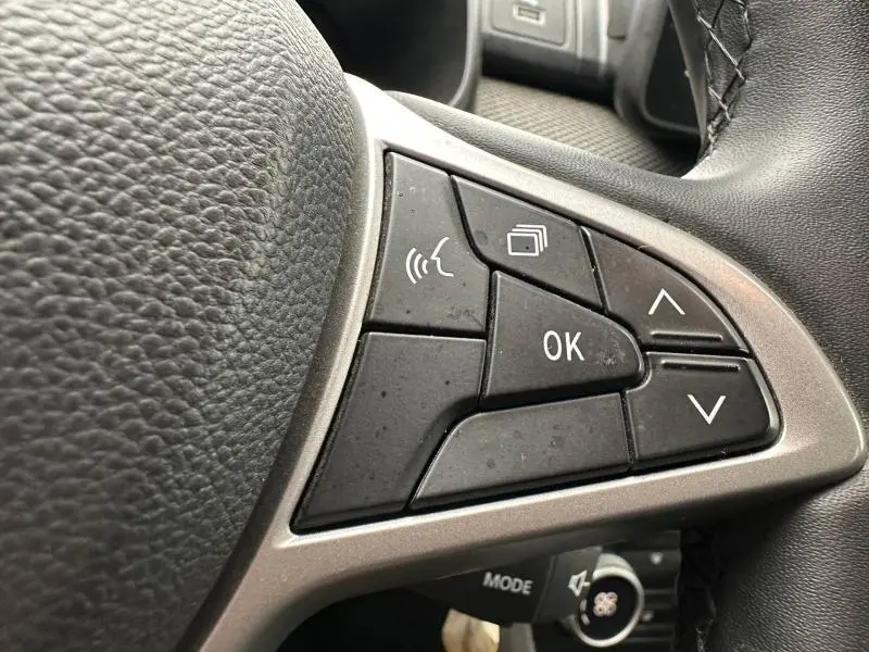 Gros plan sur les commandes multifonctions du volant du Dacia Jogger 2025, finition Expression, avec boutons noirs et contour argenté.