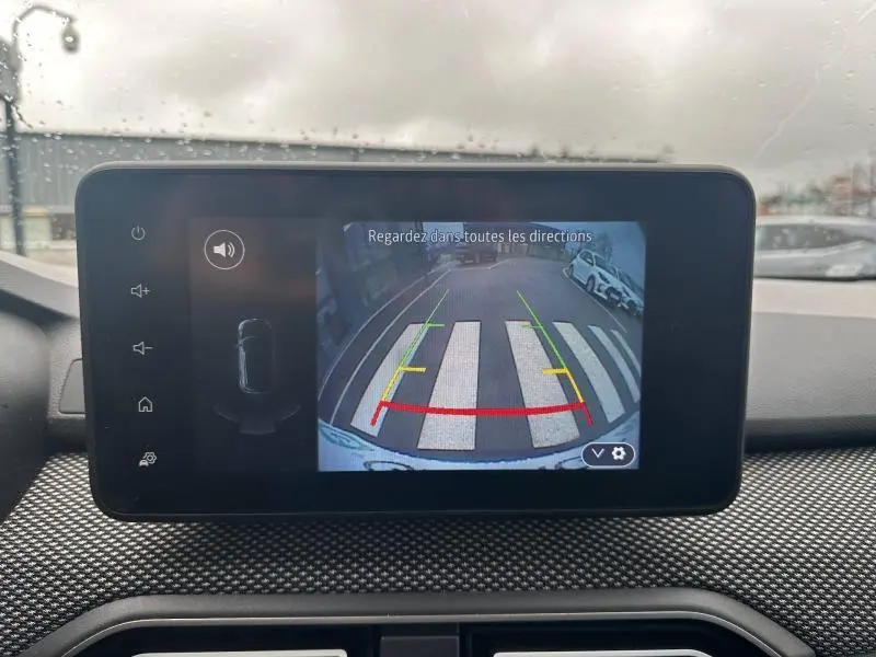 Vue depuis la caméra de recul du Dacia Jogger 2025 en Kaki Lichen, montrant un passage piéton et un stationnement arrière.