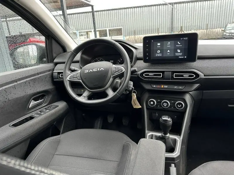 Vue intérieure côté conducteur du Dacia Jogger 2025, tableau de bord moderne avec écran tactile et levier de vitesses manuel.