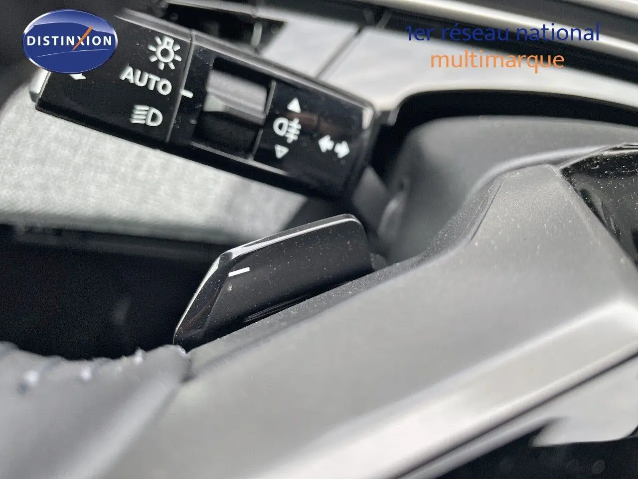 Gros plan sur la commande des feux et le levier de vitesses au volant du Peugeot 3008 noir perle métal 2025 hybride.