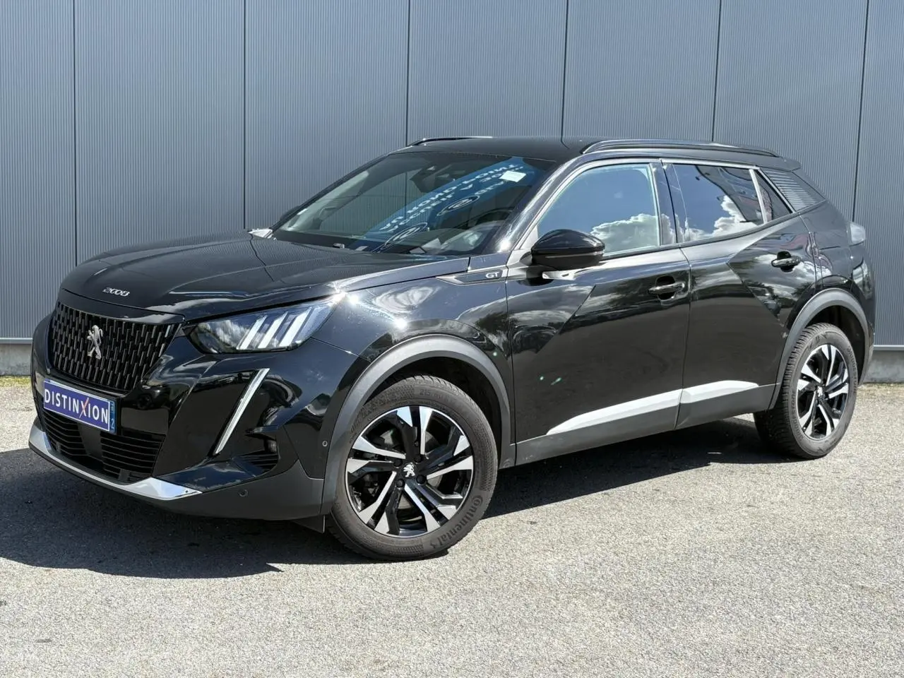 Peugeot 2008 GT noir Onyx vue 3/4 avant droit, jantes bi-tons et signature lumineuse LED 3 griffes visibles.