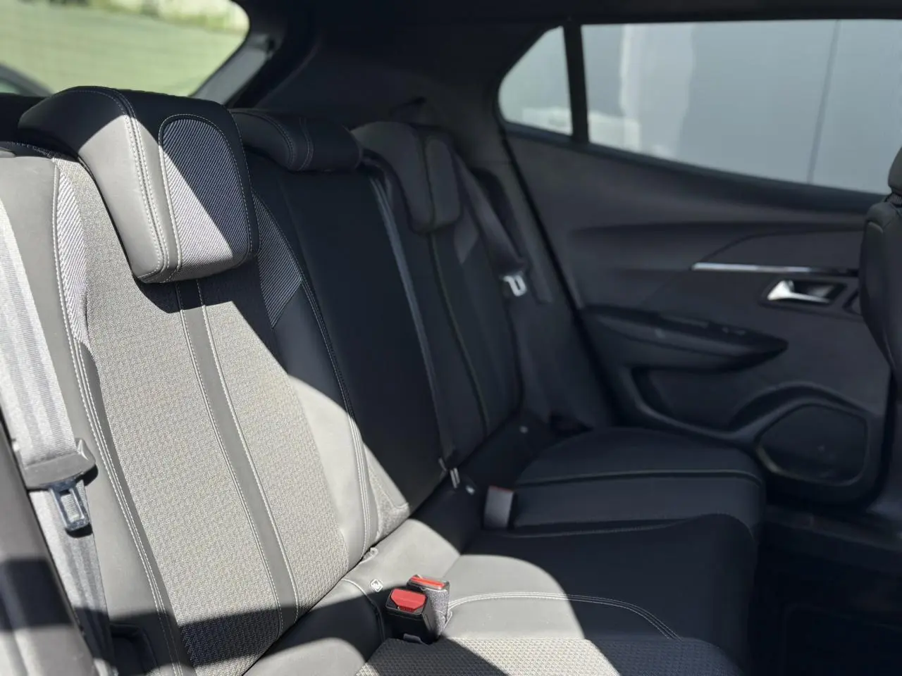 Banquette arrière noire en tissu et TEP dans l'habitacle du Peugeot 2008, vue côté droit avec porte ouverte.