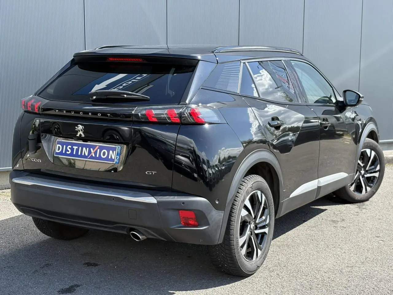 Vue 3/4 arrière droite d’un Peugeot 2008 GT noir Onyx avec feux arrière LED et jantes alliage bi-ton.
