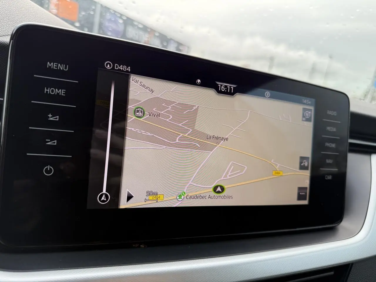 Écran tactile central du Skoda Kamiq 2023 affichant la navigation GPS avec commandes tactiles latérales.