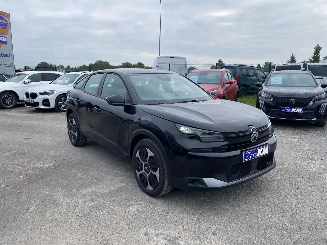 Citroën C4 hybride noire Perla Nera vue 3/4 avant droit, avec jantes spécifiques et calandre moderne.