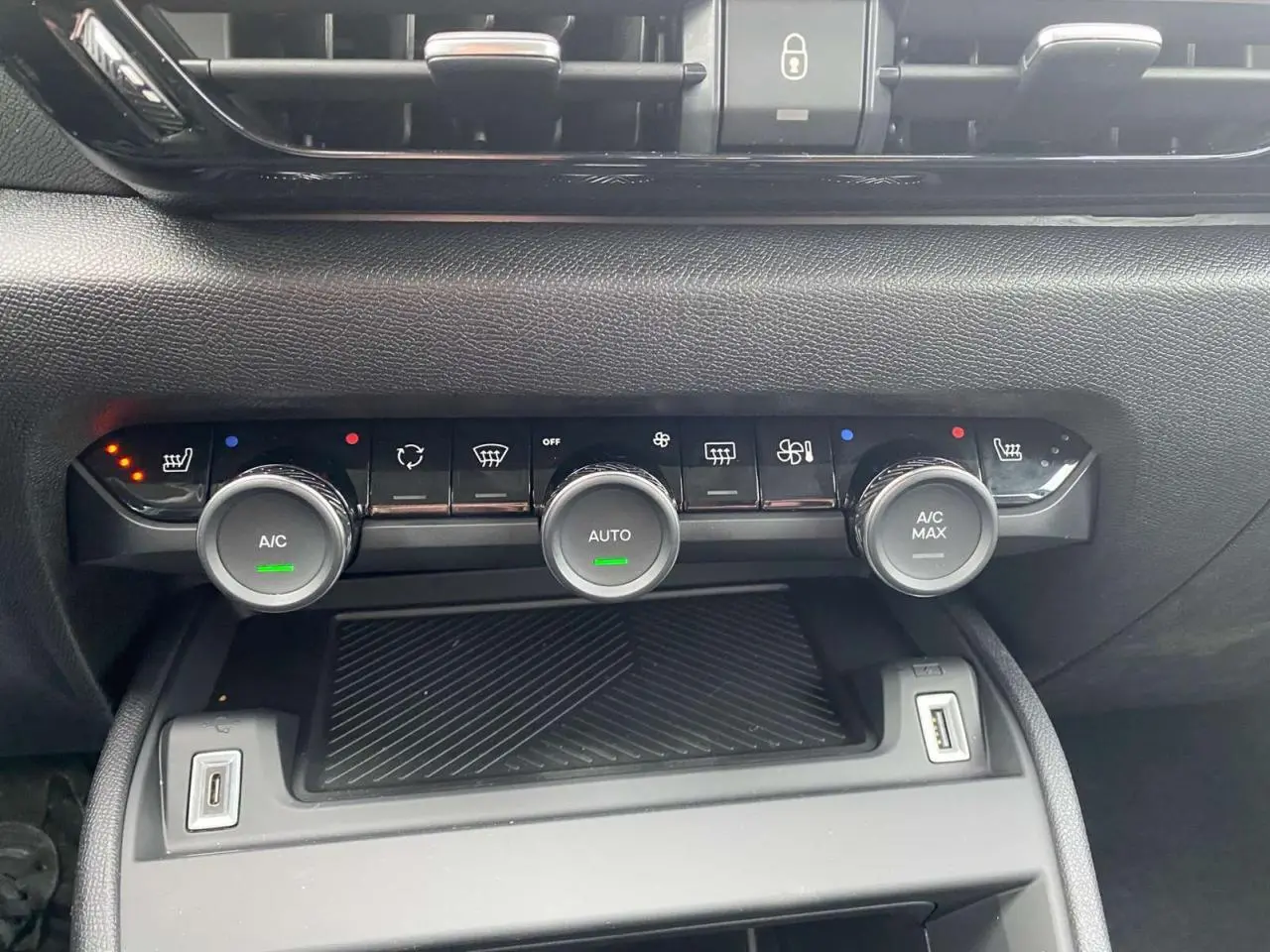 Panneau de commande de climatisation automatique bi-zone de la Citroën C4 hybride 2025, vue frontale intérieure.