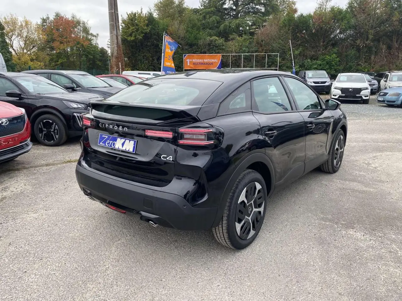 Vue 3/4 arrière droite d'une Citroën C4 noire Perla Nera avec toit noir et feux arrière LED distinctifs.