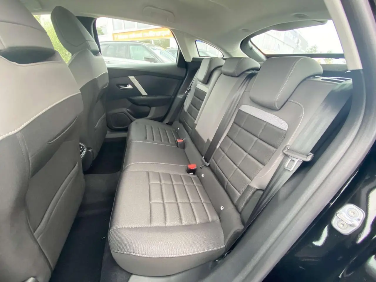 Vue intérieure côté droit sur la banquette arrière noire du Citroën C4 Nouvelle Hybride 145 E-DCS6 Plus + 2025.