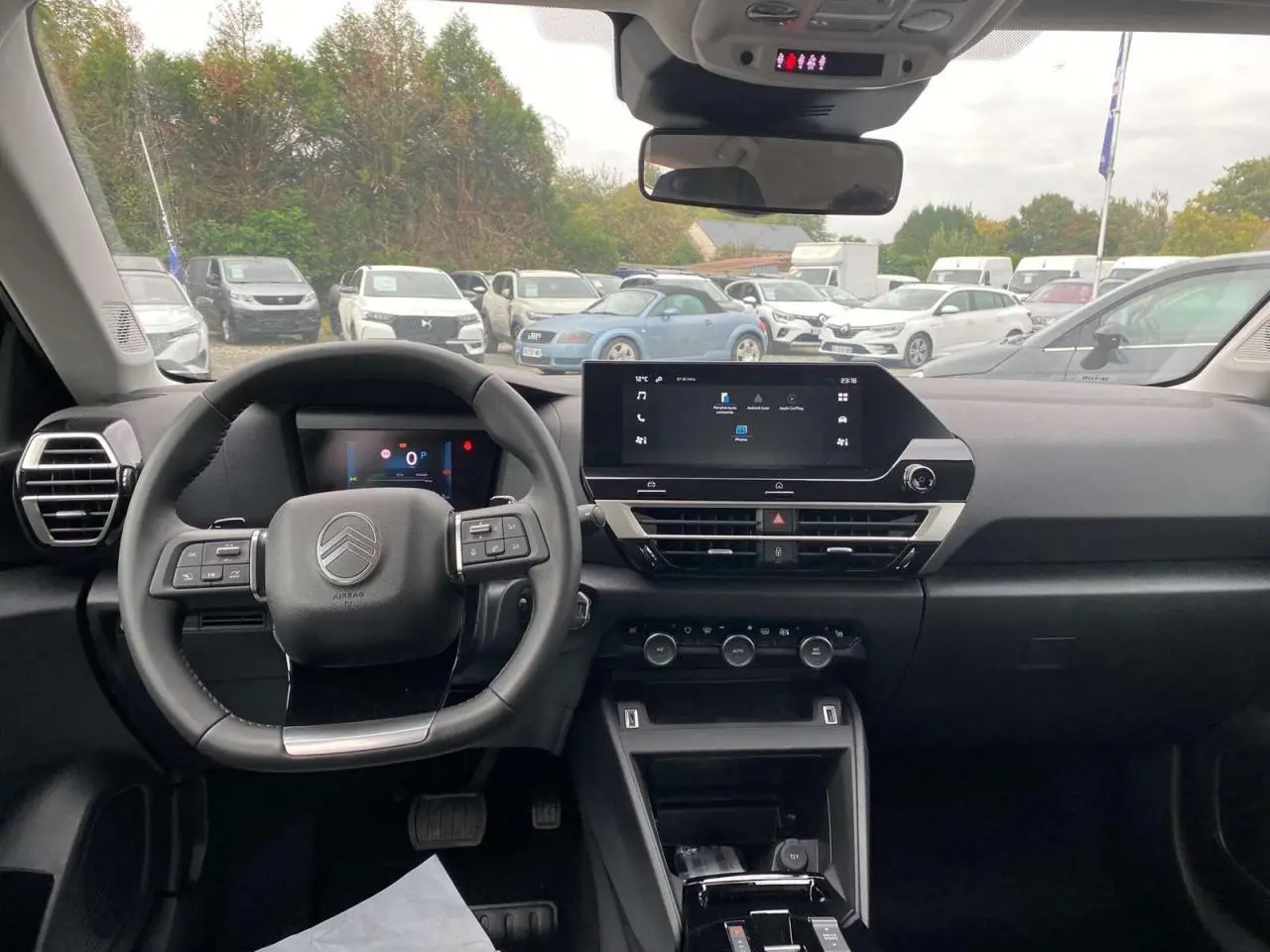 Vue intérieure avant du poste de conduite de la Citroën C4 noire, avec écran tactile central et volant multifonction.