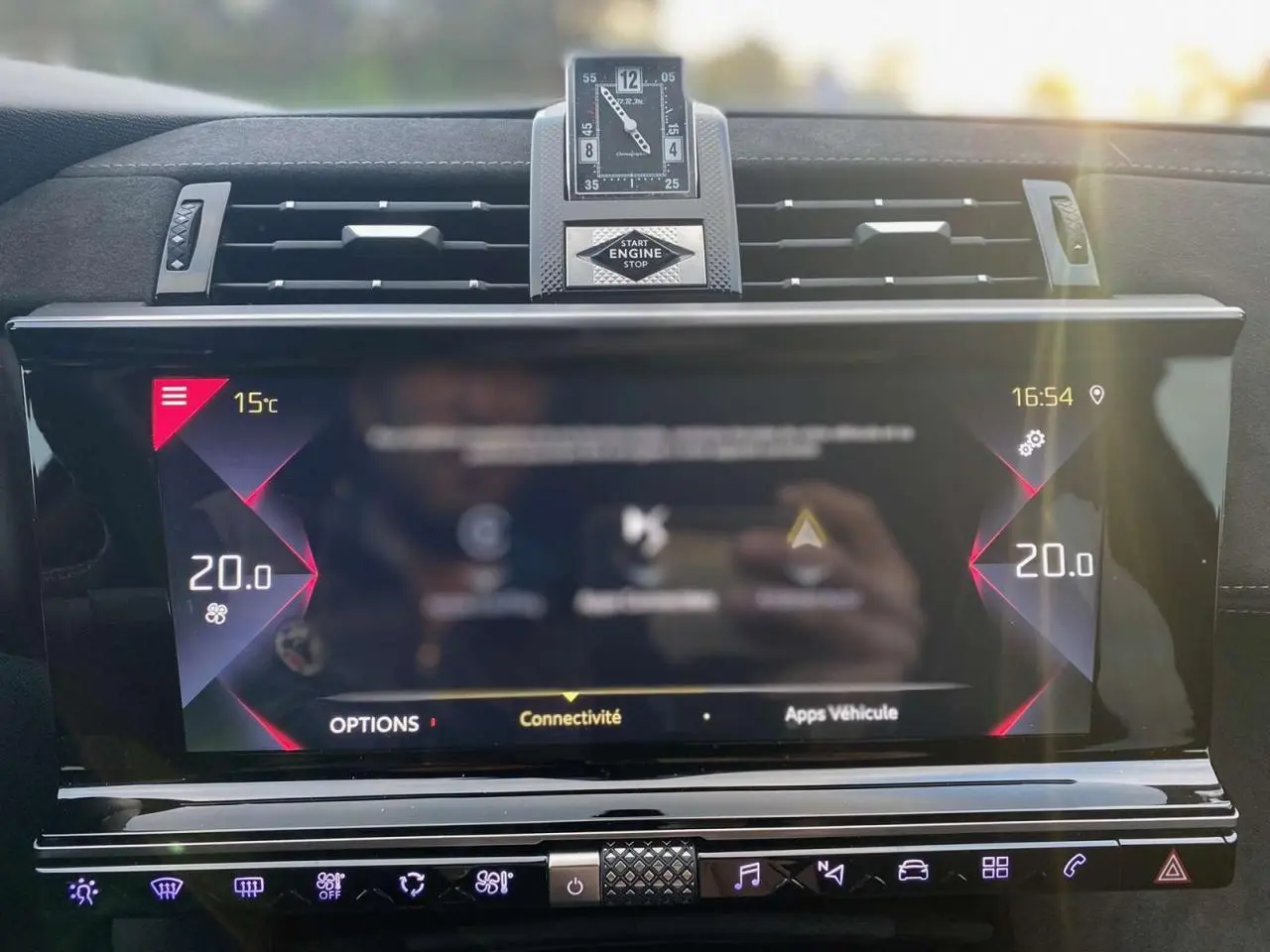 Tableau de bord du DS7 Crossback blanc 2022, vue frontale sur l'écran tactile et horloge analogique centrale.