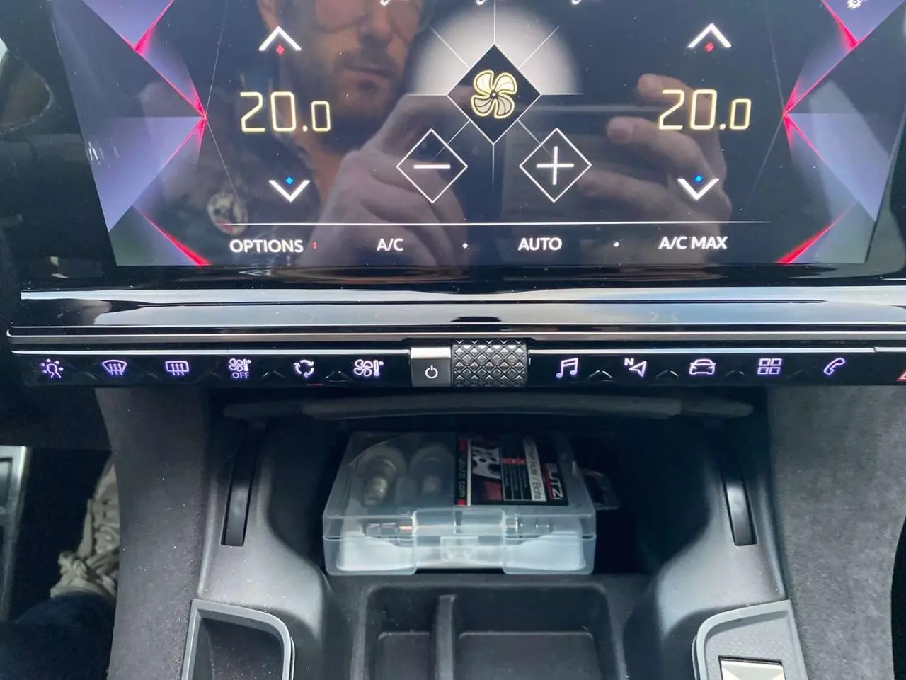 Gros plan sur la console centrale du DS7 Crossback blanc 2022, affichage digital avec commandes tactiles et rangement inférieur.
