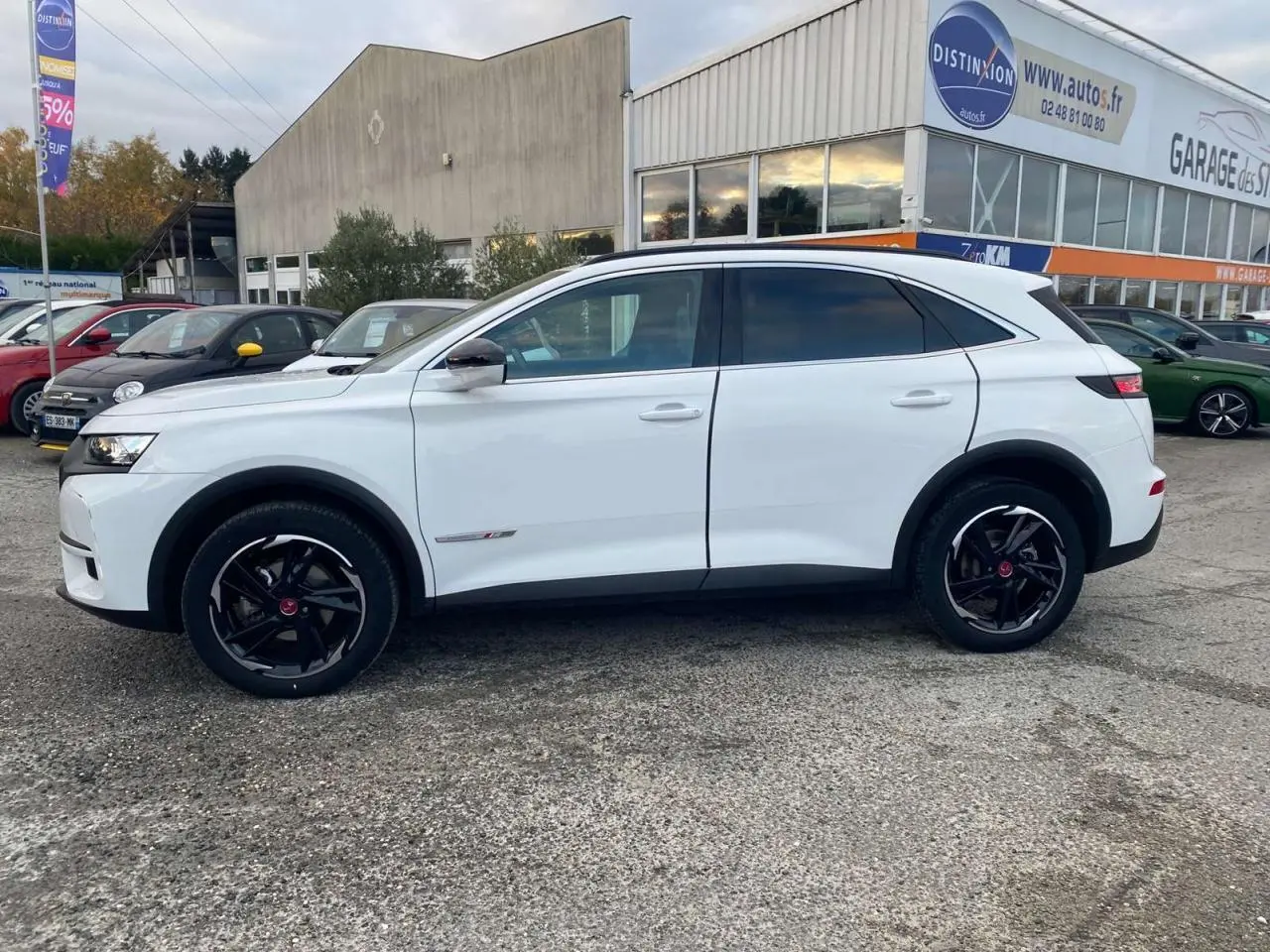 Vue de profil côté gauche d'un DS7 Crossback blanc 2022 avec jantes noires et finition Performance Line.