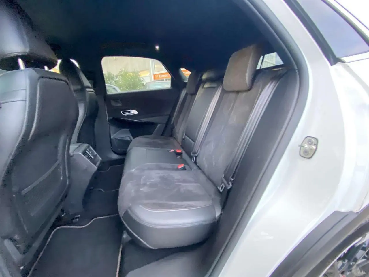 Vue intérieure arrière côté droit du DS7 Crossback blanc 2022 montrant les sièges arrière en cuir et alcantara noirs.