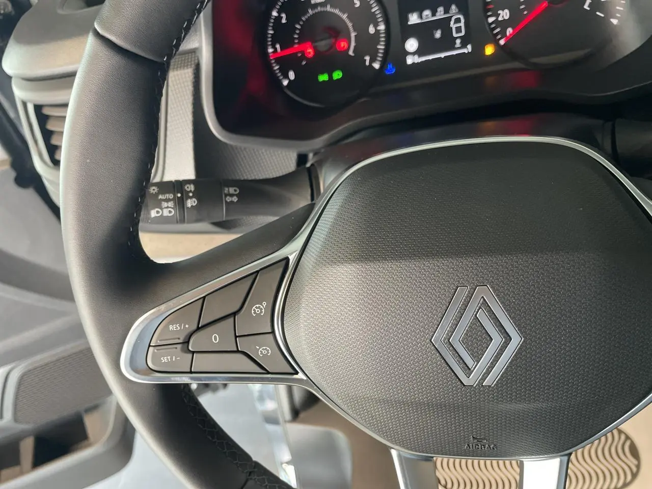 Vue rapprochée du volant noir du Renault Trafic Fourgon 2025 avec commandes intégrées et tableau de bord partiel.