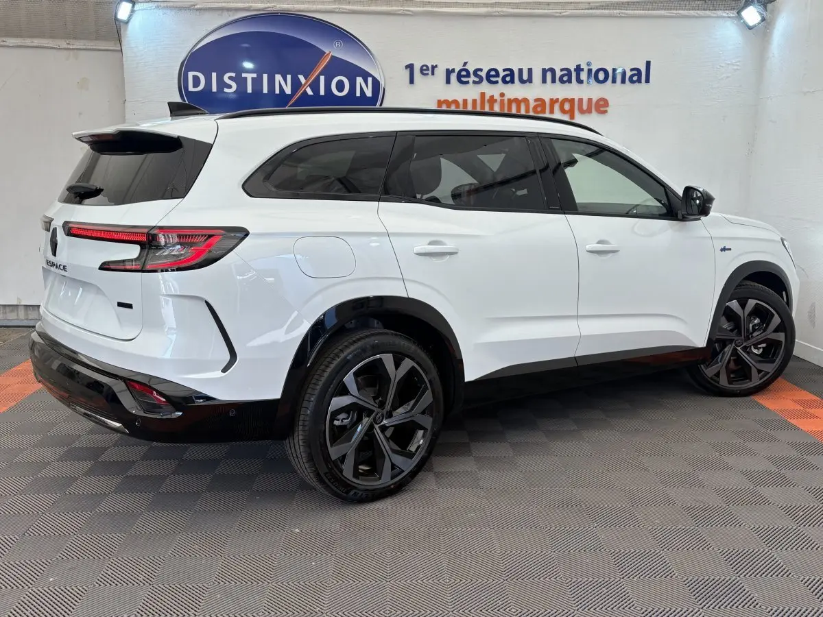 Renault Espace blanc vue 3/4 arrière droit, jantes noires, feux LED, logo E-Tech sur aile avant.