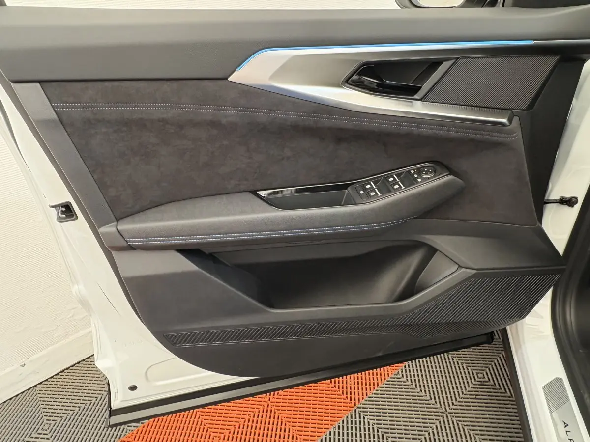 Vue rapprochée de la porte avant gauche blanche du Renault Espace esprit Alpine 2025 avec garniture noire et commandes électriques.