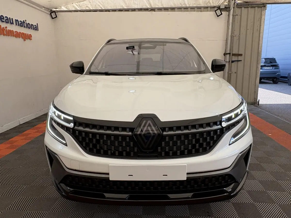 Vue frontale d'un Renault Espace blanc 2025 esprit Alpine avec calandre noire et feux LED distinctifs allumés.