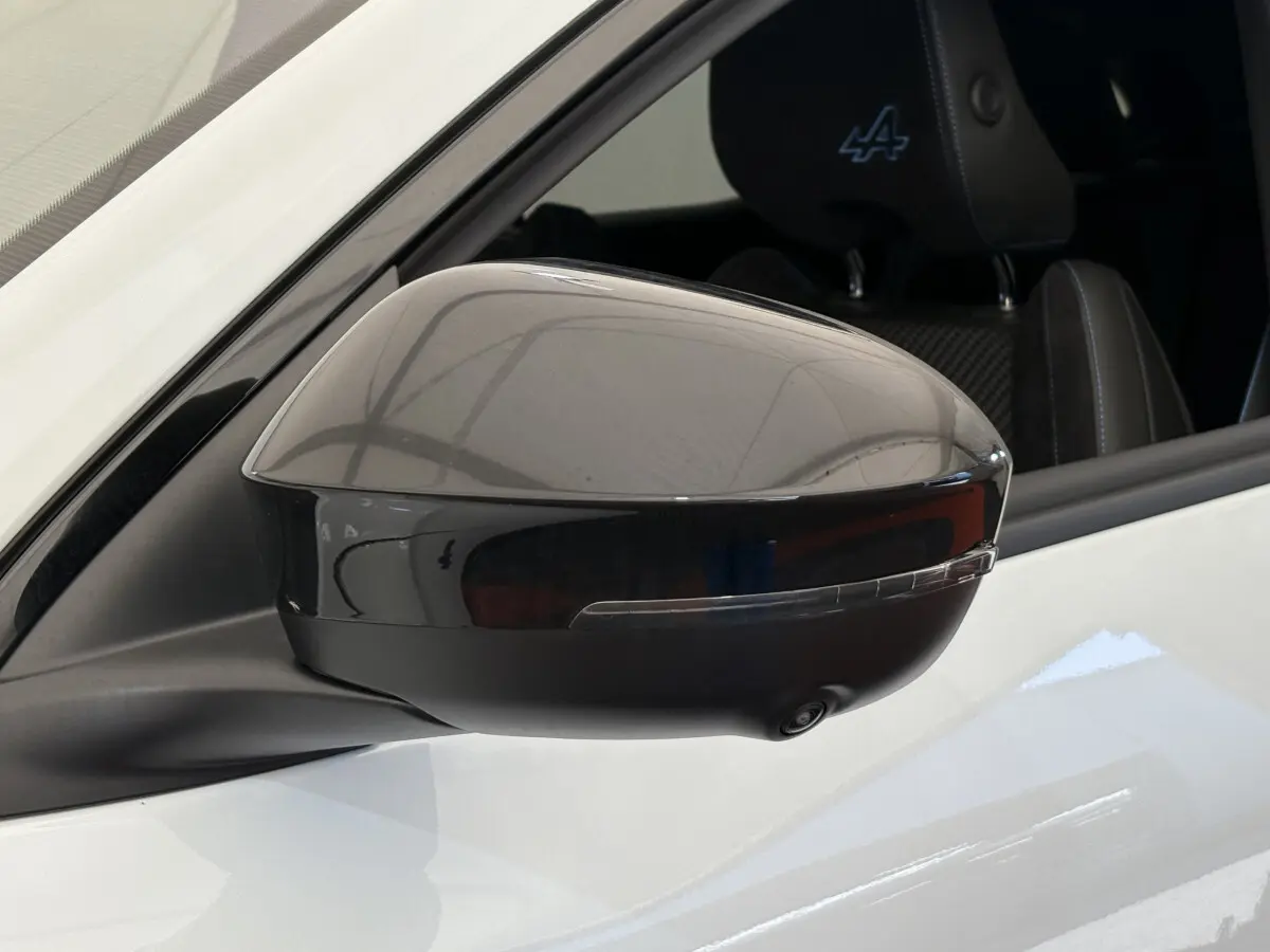 Rétroviseur extérieur droit noir brillant sur Renault Espace blanc esprit Alpine, avec siège avant brodé logo Alpine visible.