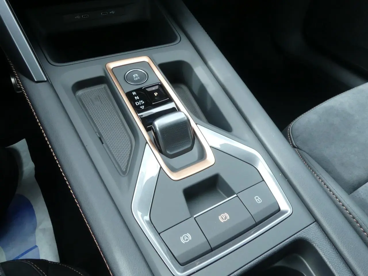 Gros plan sur la console centrale du CUPRA Formentor gris magnétique, avec levier de vitesses et surpiqûres cuivrées.