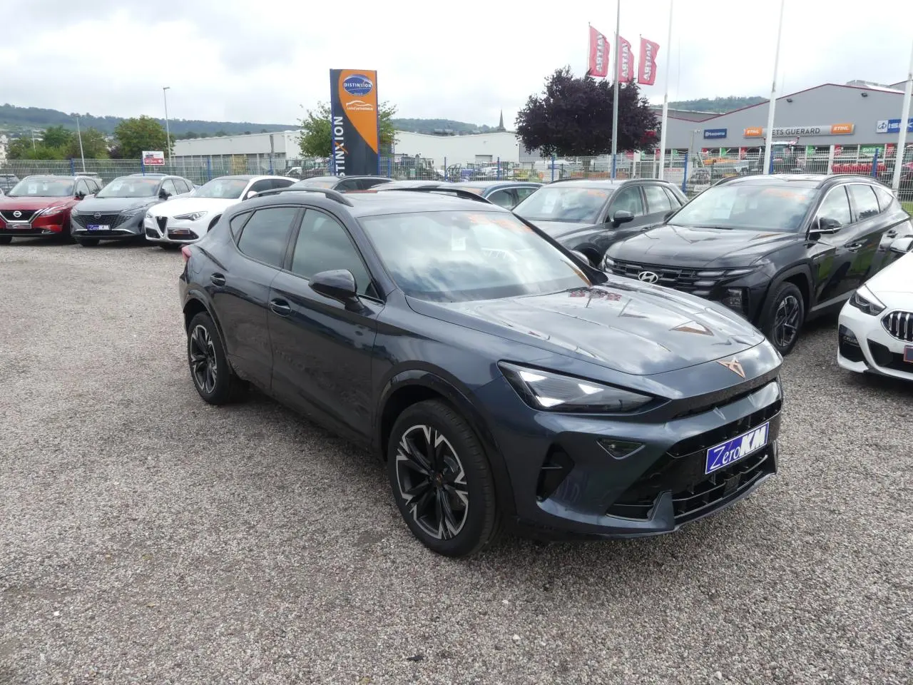 Vue 3/4 avant gauche d'une CUPRA Formentor gris magnétique avec jantes alliage et toit ouvrant panoramique visible.