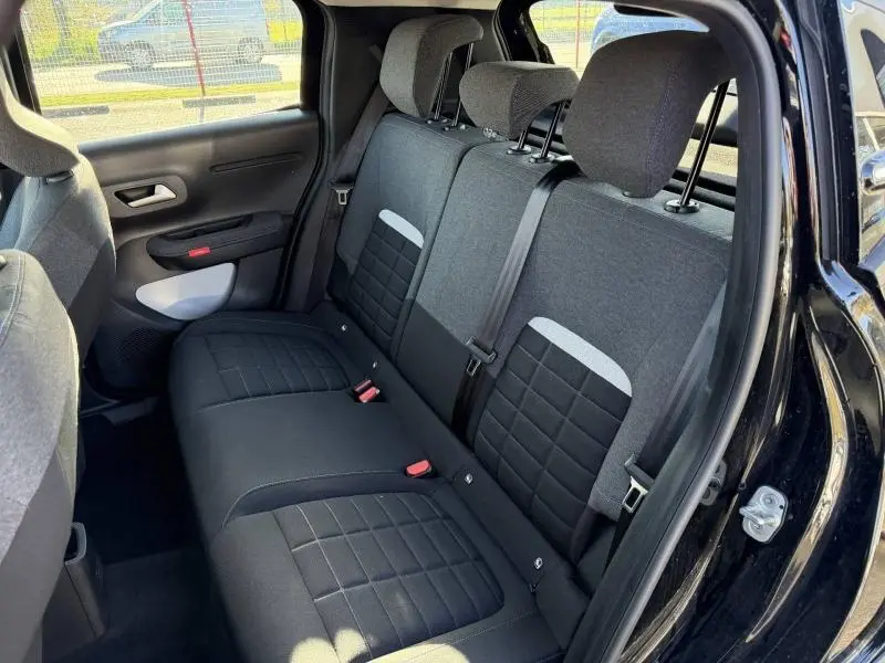 Vue intérieure côté arrière droit de la banquette arrière noire avec détails gris de la Citroën C3 1.2 Turbo 100ch PLUS 2025.