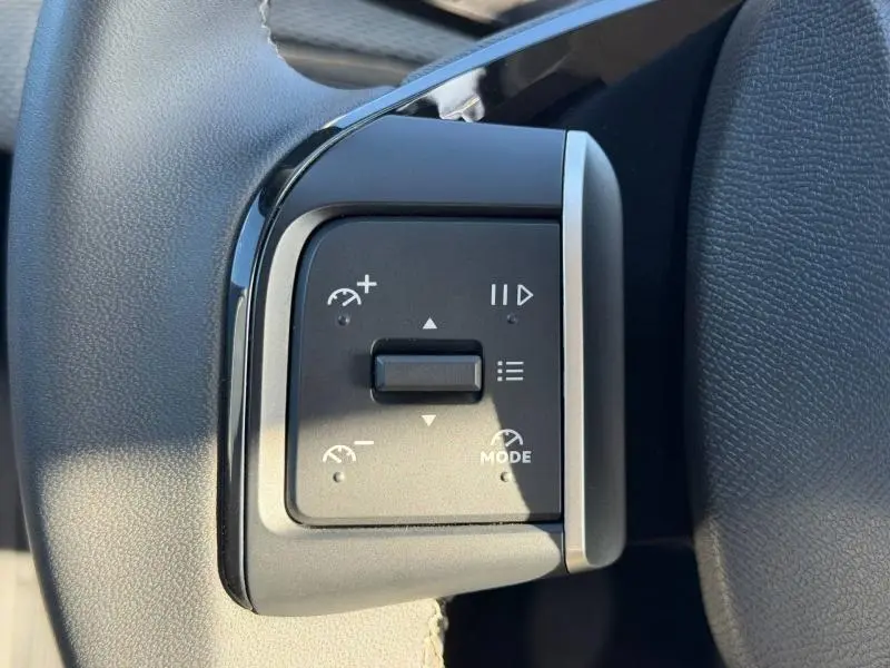 Gros plan sur les commandes de régulateur de vitesse au volant d'une Citroën C3 1.2 Turbo 100ch PLUS 2025 noir Perla Nera.