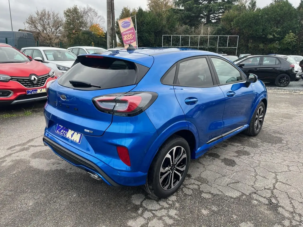 Vue 3/4 arrière droite d'un Ford Puma bleu métallisé avec jantes alliage noires et badges ST-Line visibles.