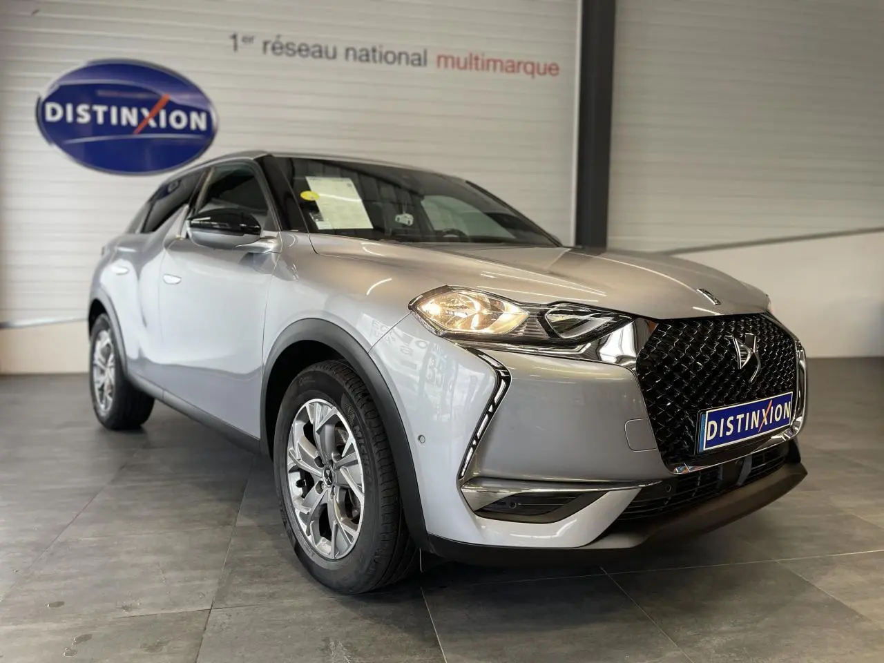 DS3 Crossback gris Artense en 3/4 avant droit, avec calandre noire distinctive et jantes alliage 17 pouces.