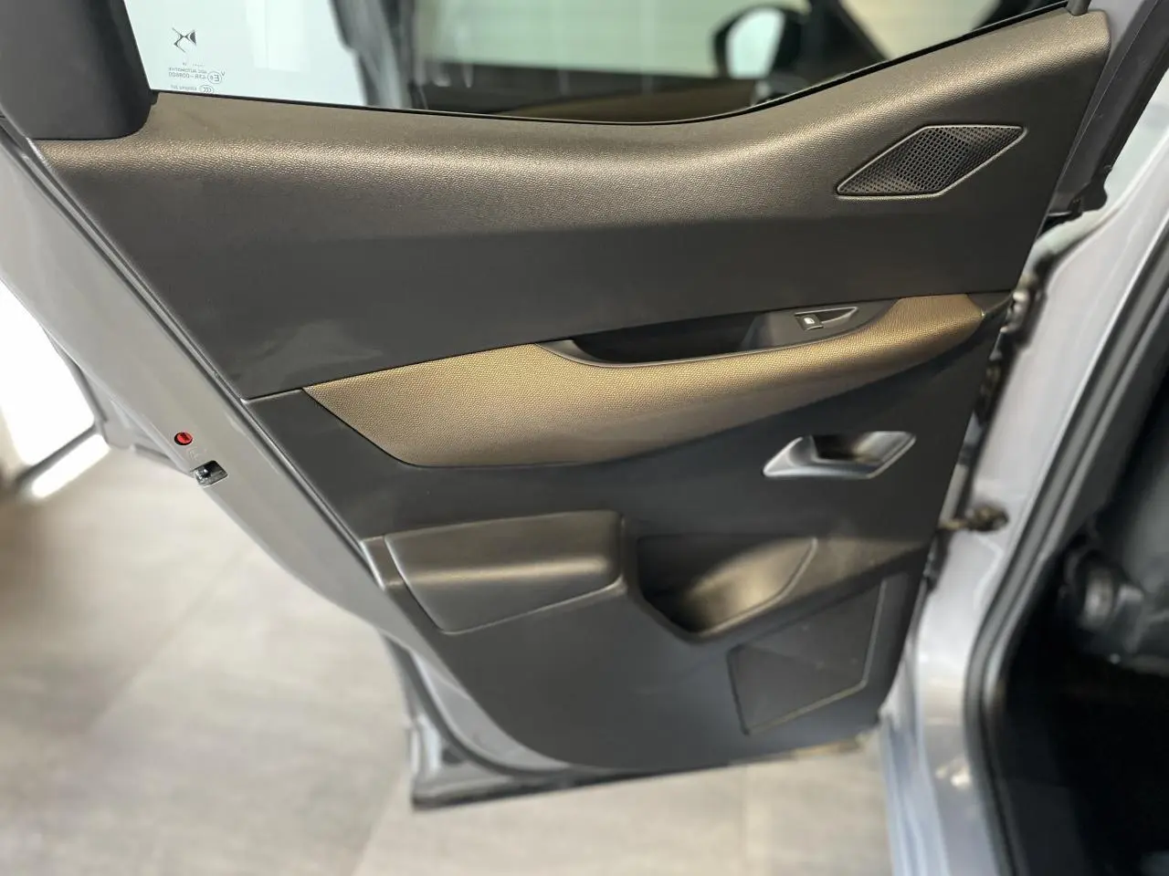Gros plan sur la porte arrière gauche gris Artense du DS3 Crossback 2020 avec habillage noir et insert marron.