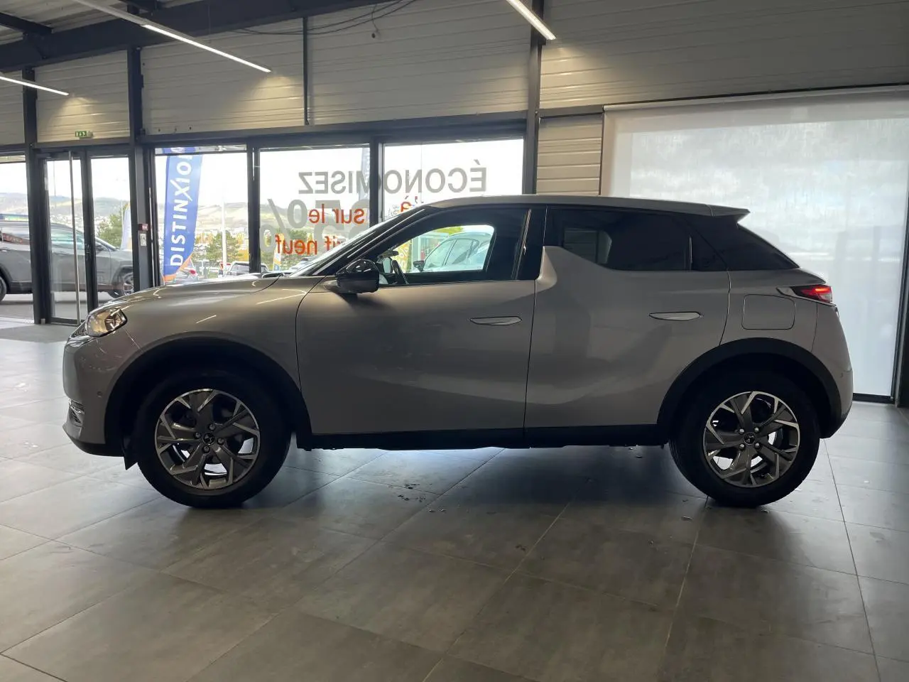 DS3 Crossback gris Artense vu de profil côté gauche, avec jantes alliage et toit noir contrasté.