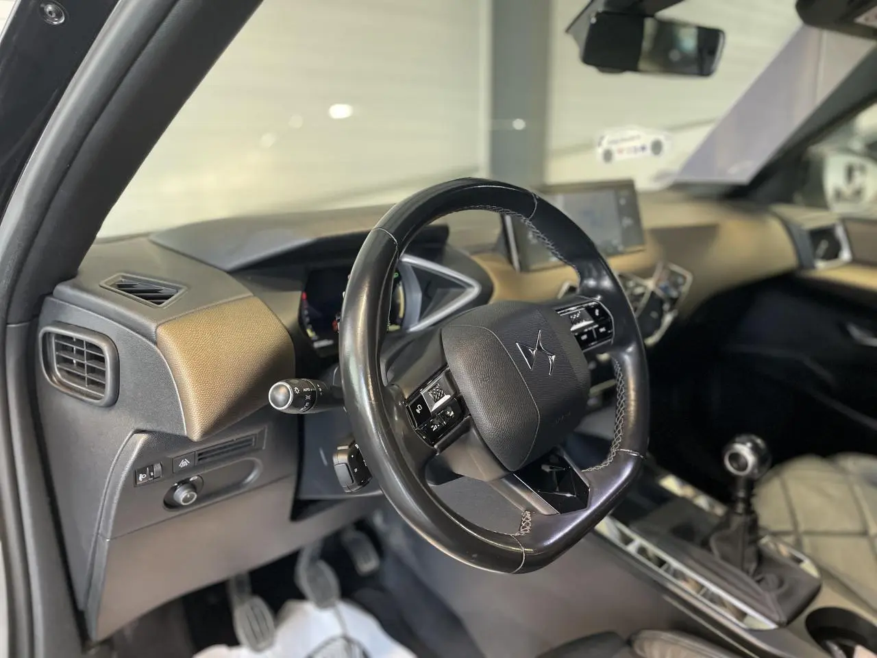 Vue intérieure côté conducteur du DS3 Crossback 2020, volant cuir noir et levier de vitesses manuel visible.