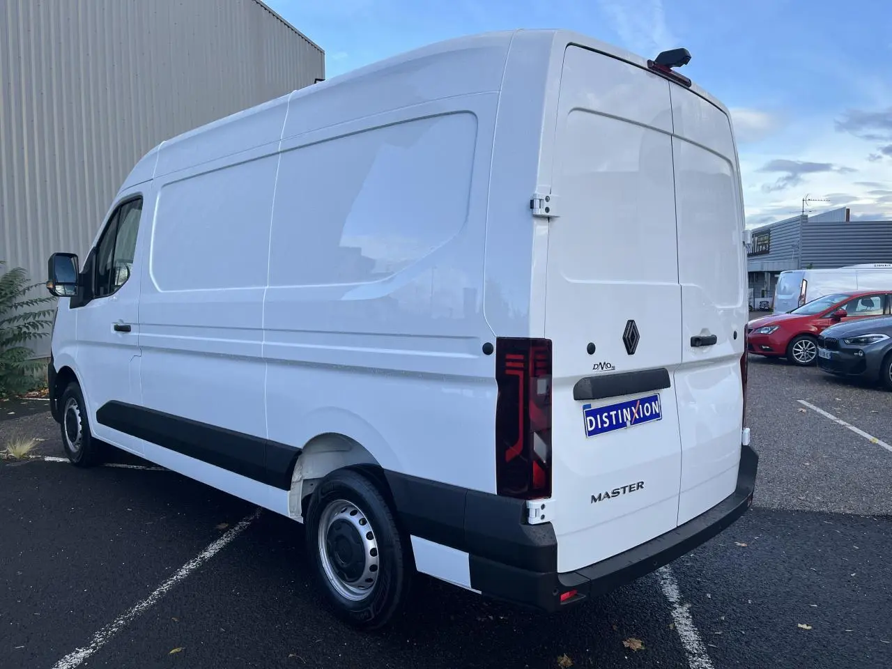 Renault Master blanc en vue 3/4 arrière droit, fourgon tôlé avec feux arrière verticaux et jantes tôle 16 pouces.
