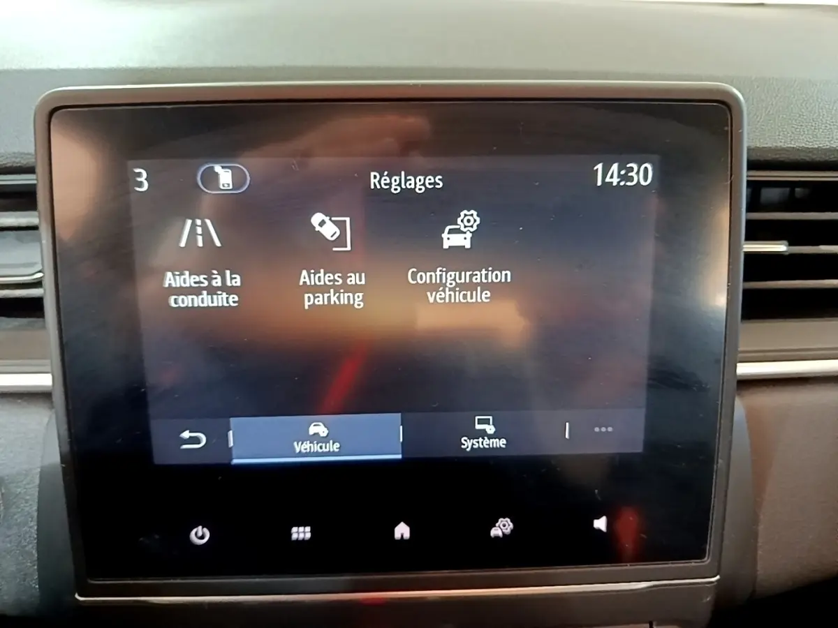 Écran tactile central du tableau de bord du Renault Captur Business 2021 affichant les réglages d’aides à la conduite et au parking.