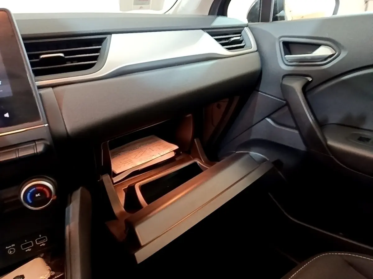 Intérieur noir du Renault Captur Business 2021, vue côté passager avec boîte à gants ouverte et tableau de bord visible.