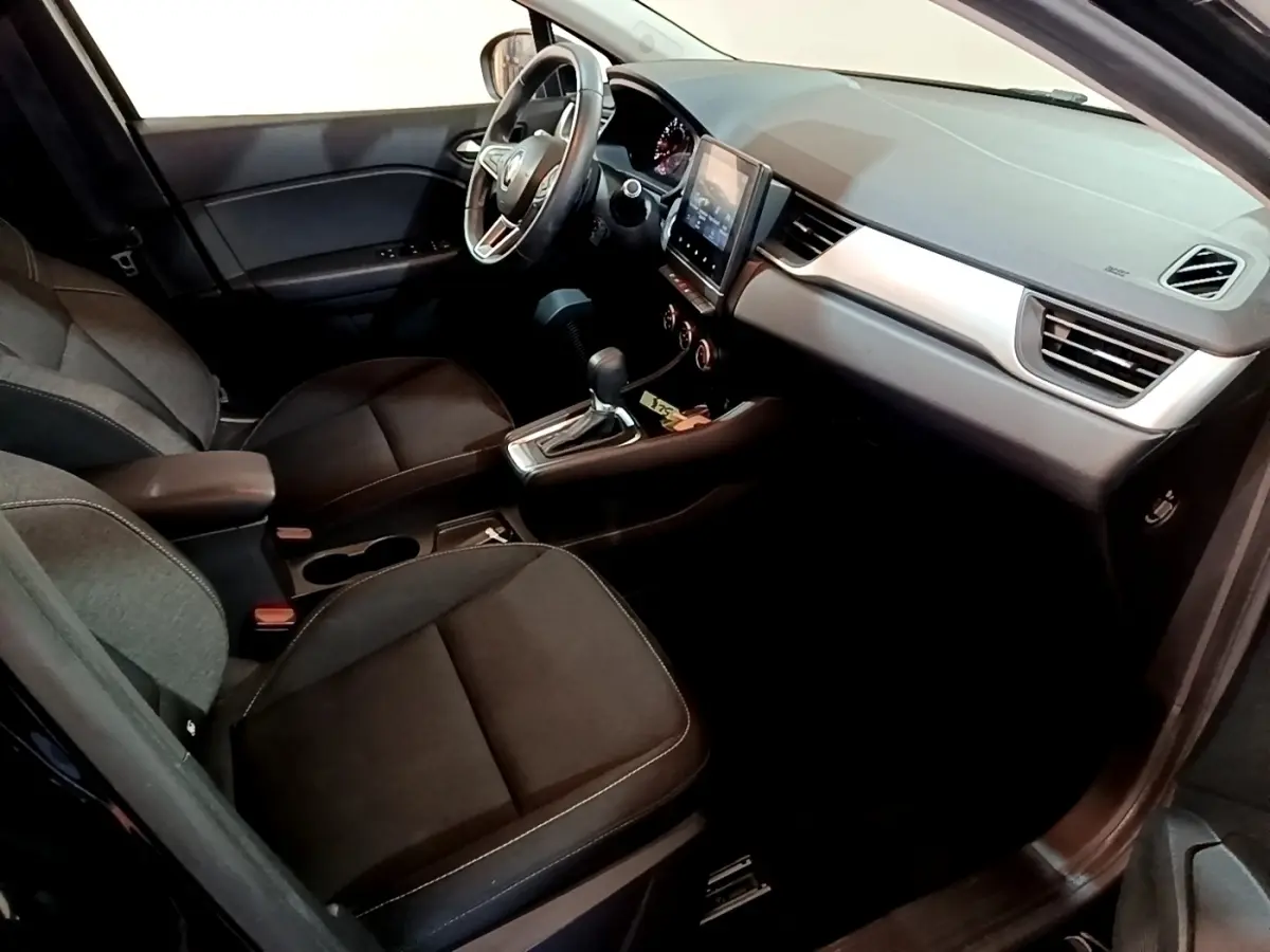 Vue intérieure côté conducteur du Renault Captur Business 2021, montrant sièges noirs et tableau de bord avec écran tactile central.