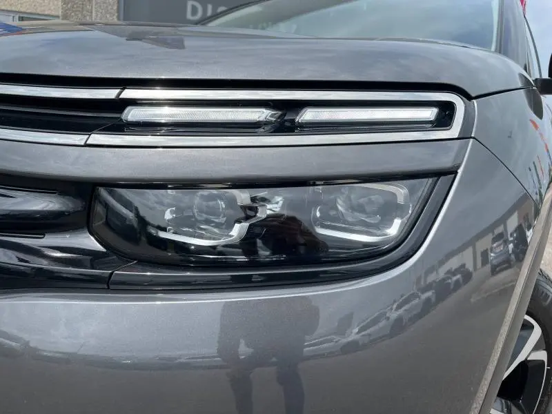 Gros plan sur le phare avant droit du Citroën C5 Aircross gris acier, soulignant son design LED distinctif.