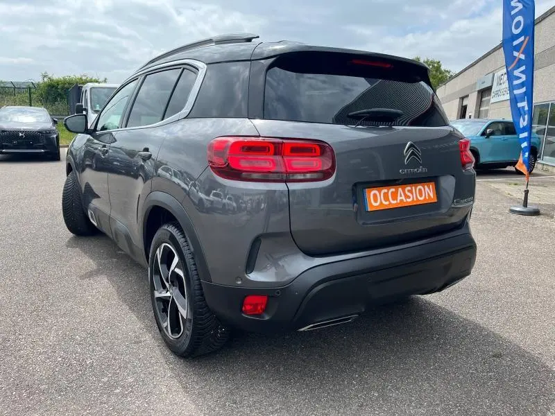 Vue 3/4 arrière droite du Citroën C5 Aircross gris acier avec feux arrière LED et toit noir brillant.