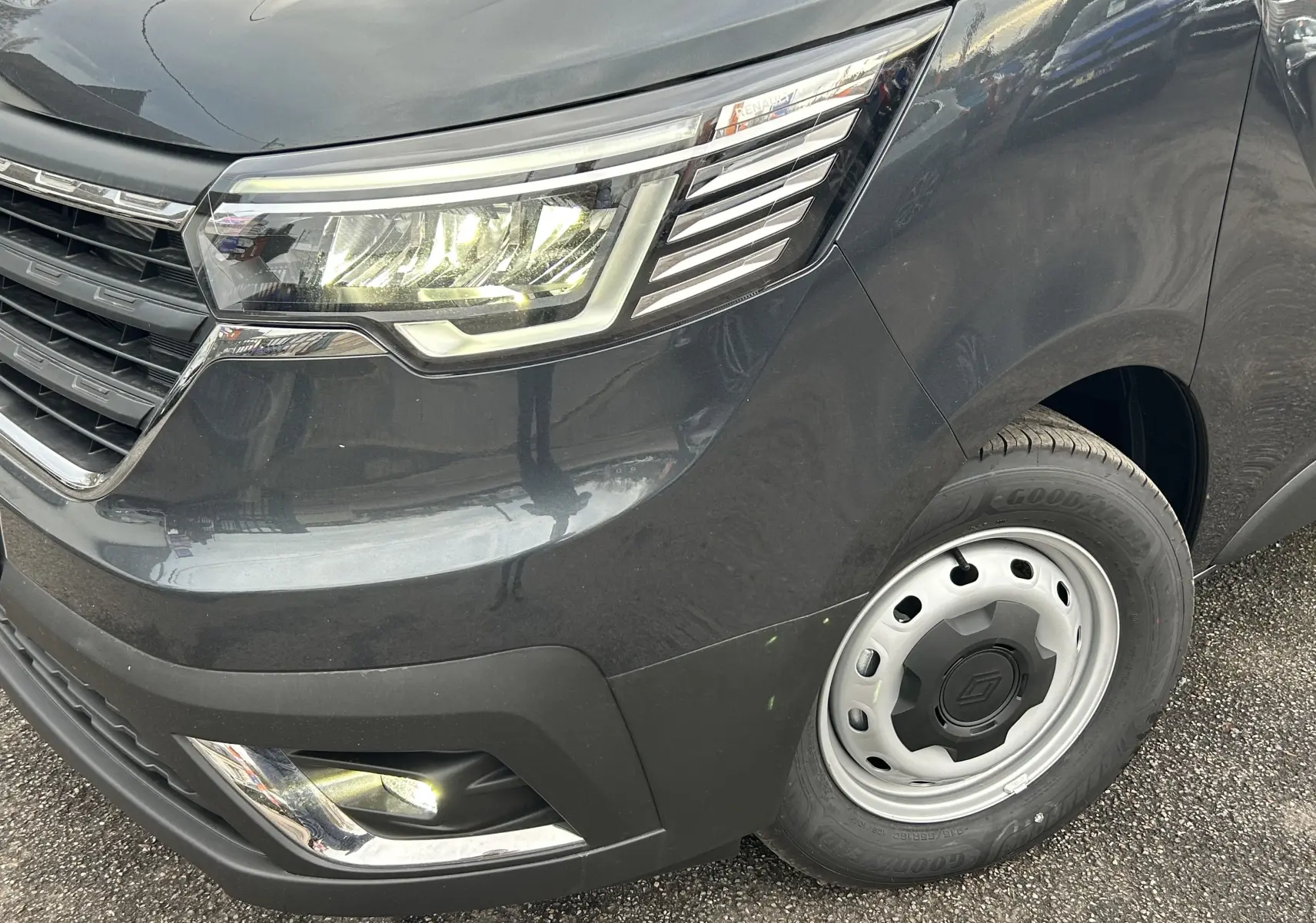 Gros plan sur l'avant droit gris Comète du Renault Trafic Fourgon avec phare LED et jante acier.