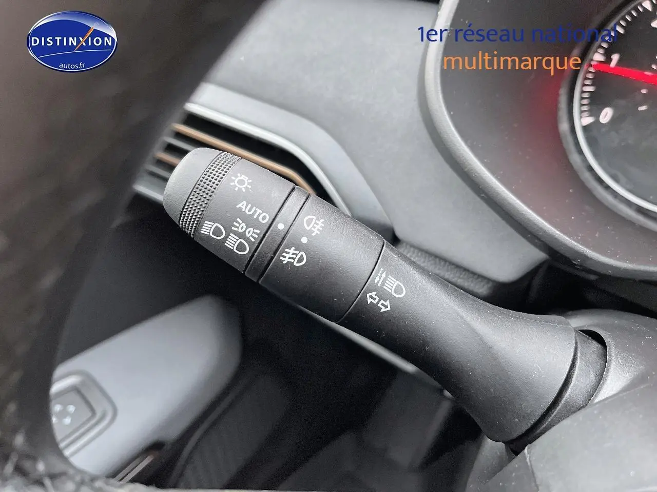 Gros plan sur la commande des phares et clignotants du tableau de bord d’un Dacia Jogger blanc 2025.