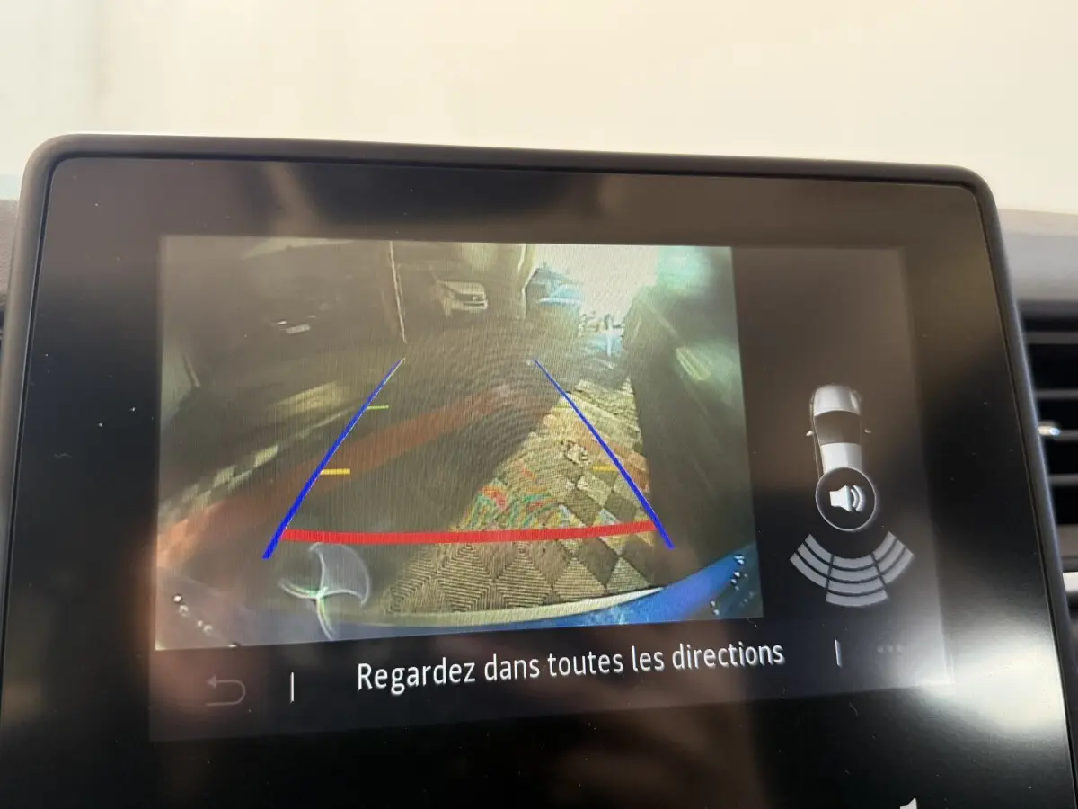 Écran tactile intérieur montrant la caméra de recul avec lignes de guidage du Renault Captur bleu, version 2024.