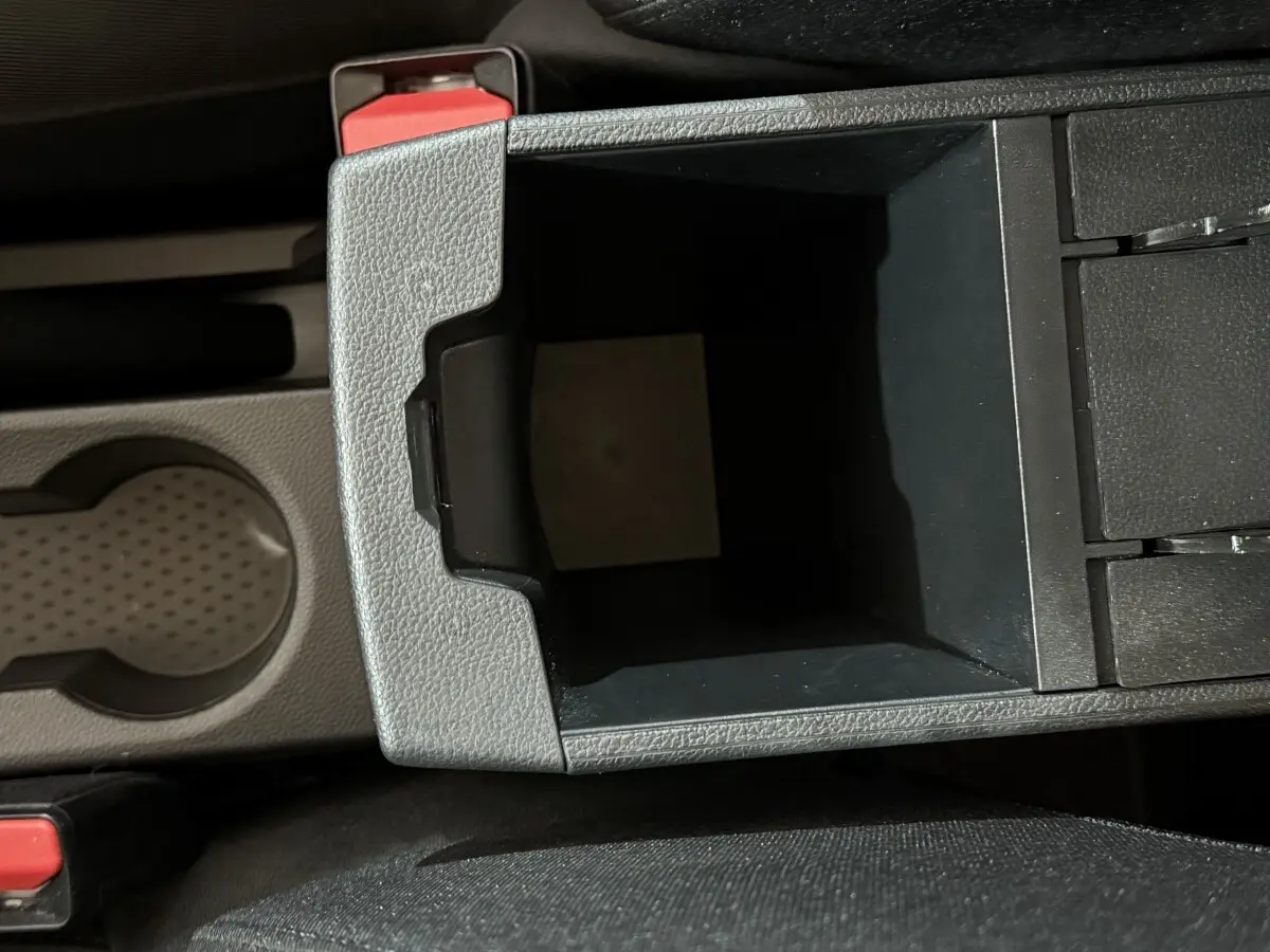 Vue en plongée du rangement central noir et gris avec porte-gobelet du Renault Captur 2024 intérieur.