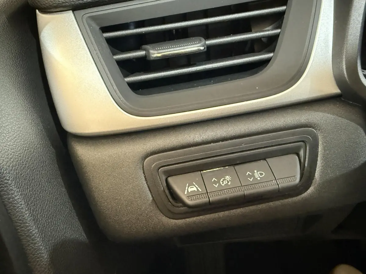 Détail du tableau de bord noir et gris du Renault Captur 2024 avec commandes d'assistance à la conduite.