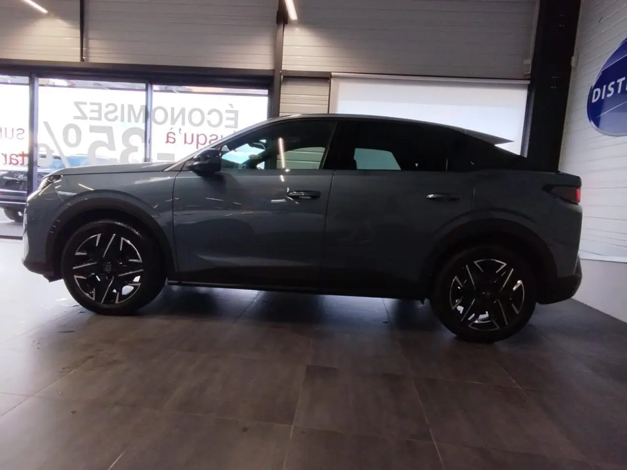 Profil côté gauche du Peugeot 3008 2025 bleu métallisé avec jantes alliage noires et vitres teintées.