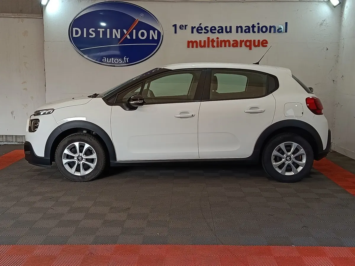 Vue latérale droite d'une Citroën C3 blanche 2020 avec jantes alliage et protections noires sur les passages de roues.