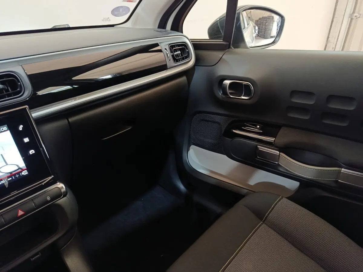 Intérieur avant droit de la Citroën C3 blanche 2020, avec tableau de bord noir brillant et écran tactile.
