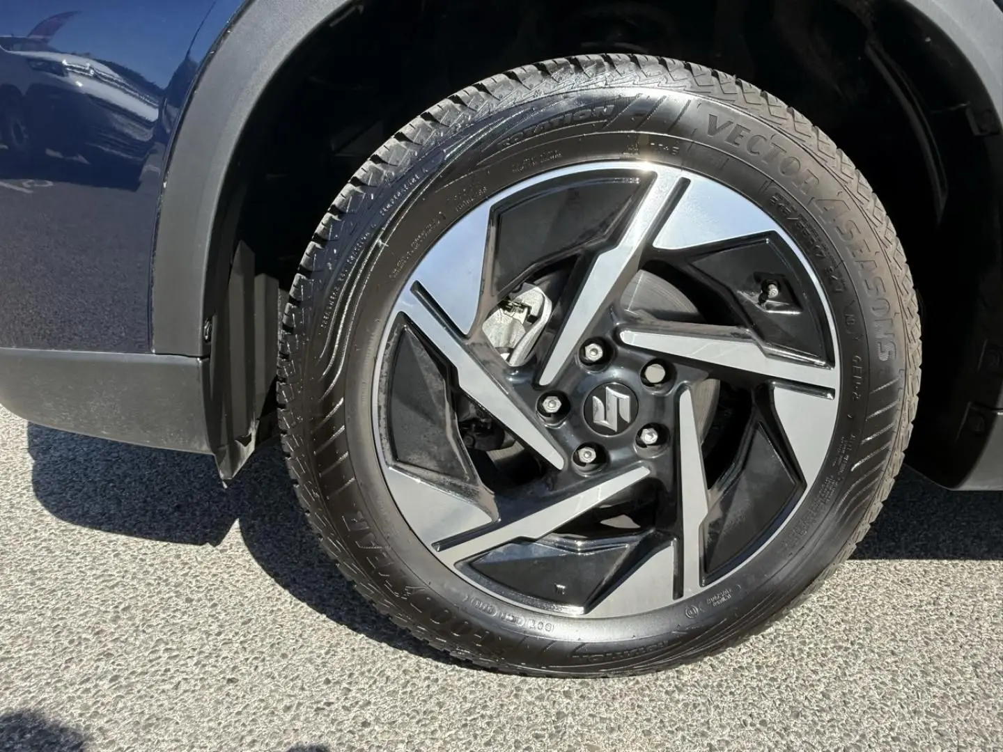 Gros plan sur la roue avant gauche du Suzuki Vitara 2025 bleu foncé, mettant en valeur la jante alliage au design moderne.