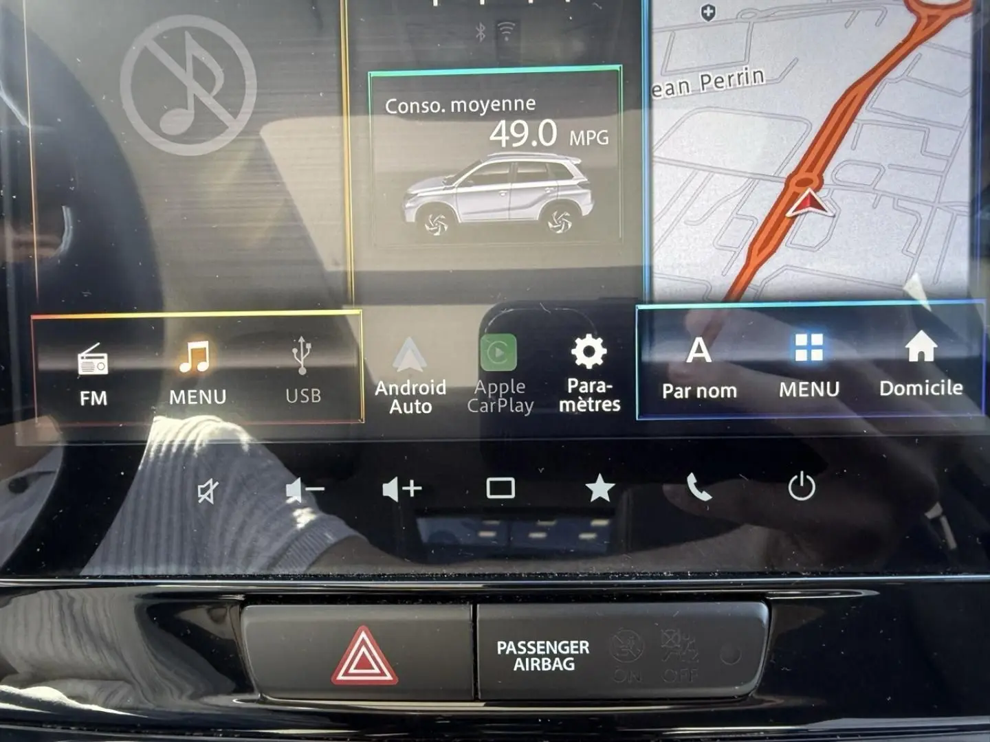 Image du tableau de bord du Suzuki Vitara 2025, écran tactile central affichant la consommation moyenne et la navigation.