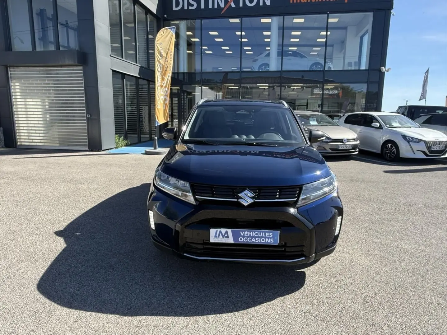 Vue avant d'un Suzuki Vitara 2025 bleu foncé métal, avec calandre noire et logo Suzuki bien visible.